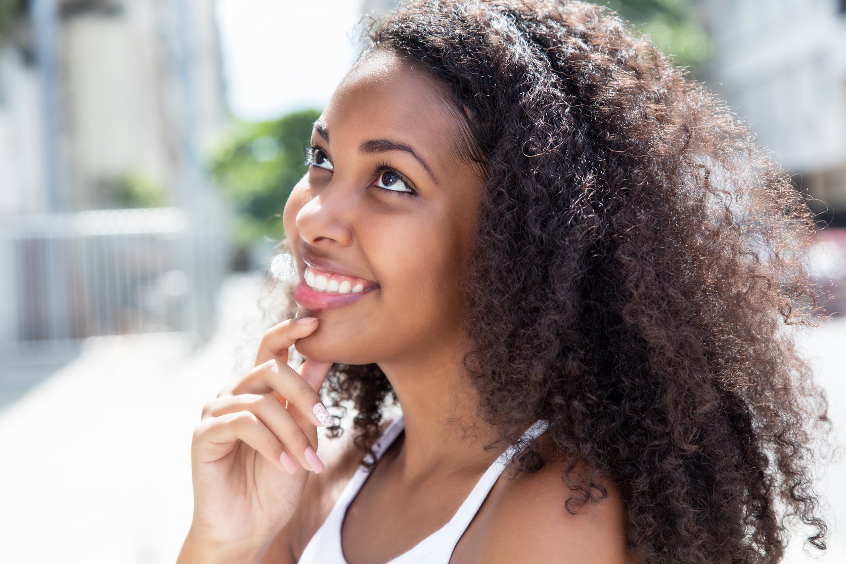 Dreaming latin woman with curly hair in city